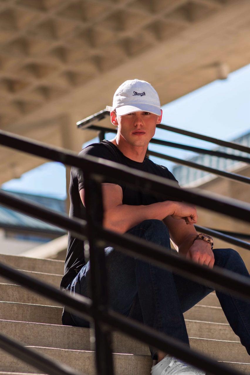 Seated in the Strength cap and Signature Tee